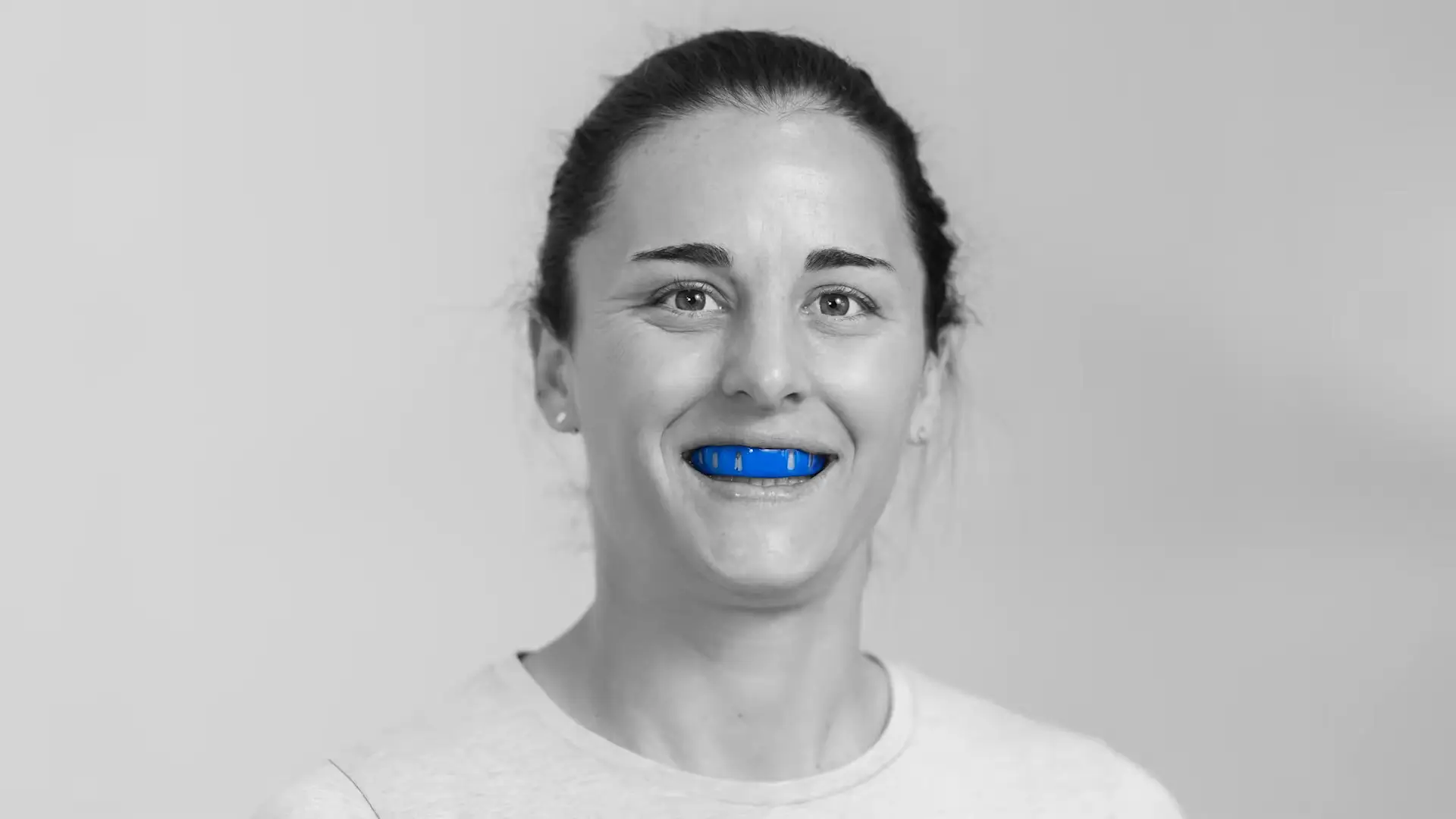 Female sports person wearing a blue Neomorph Mouthguard