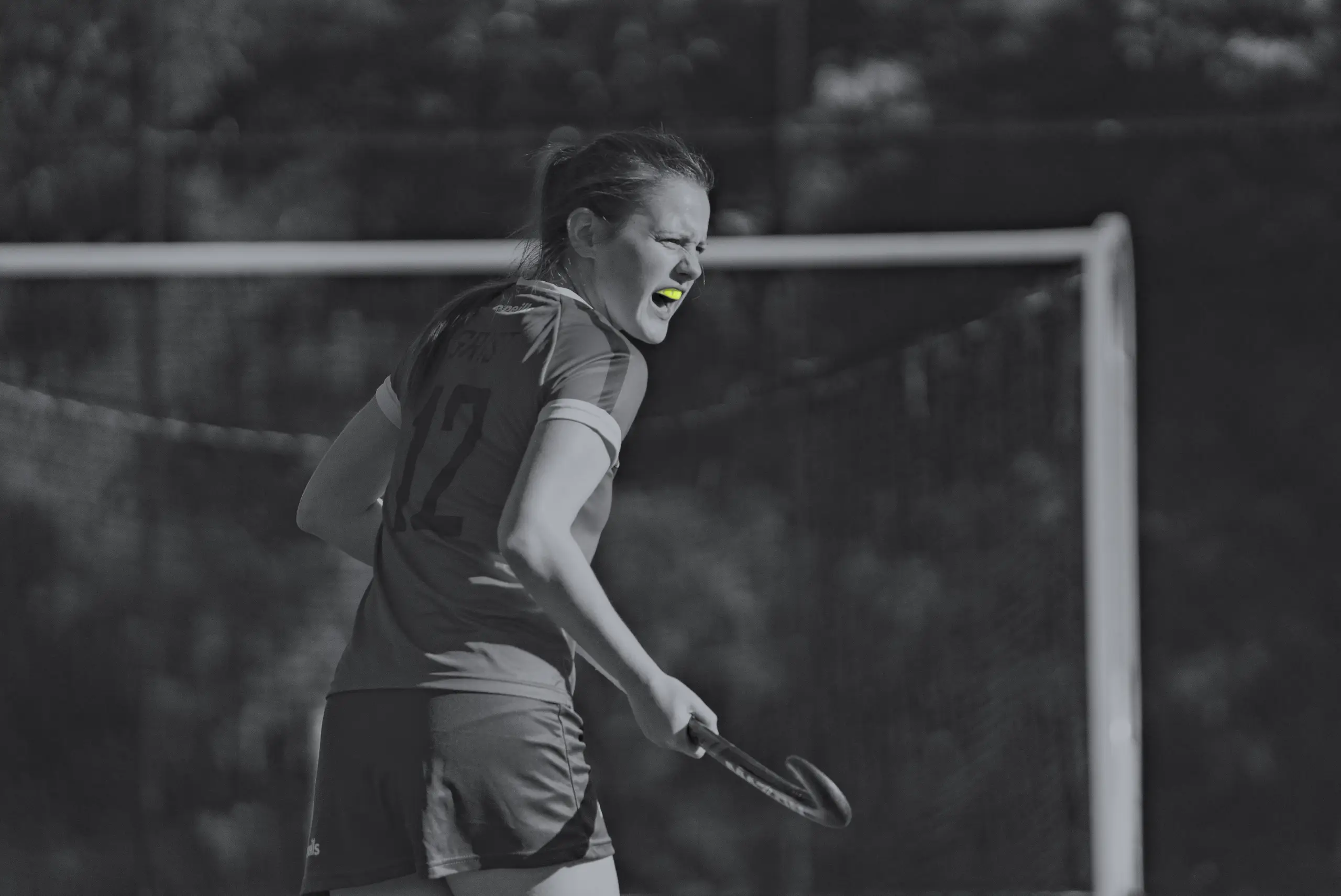 Female sports person playing hockey with Lime Green Neomorph Mouthguard